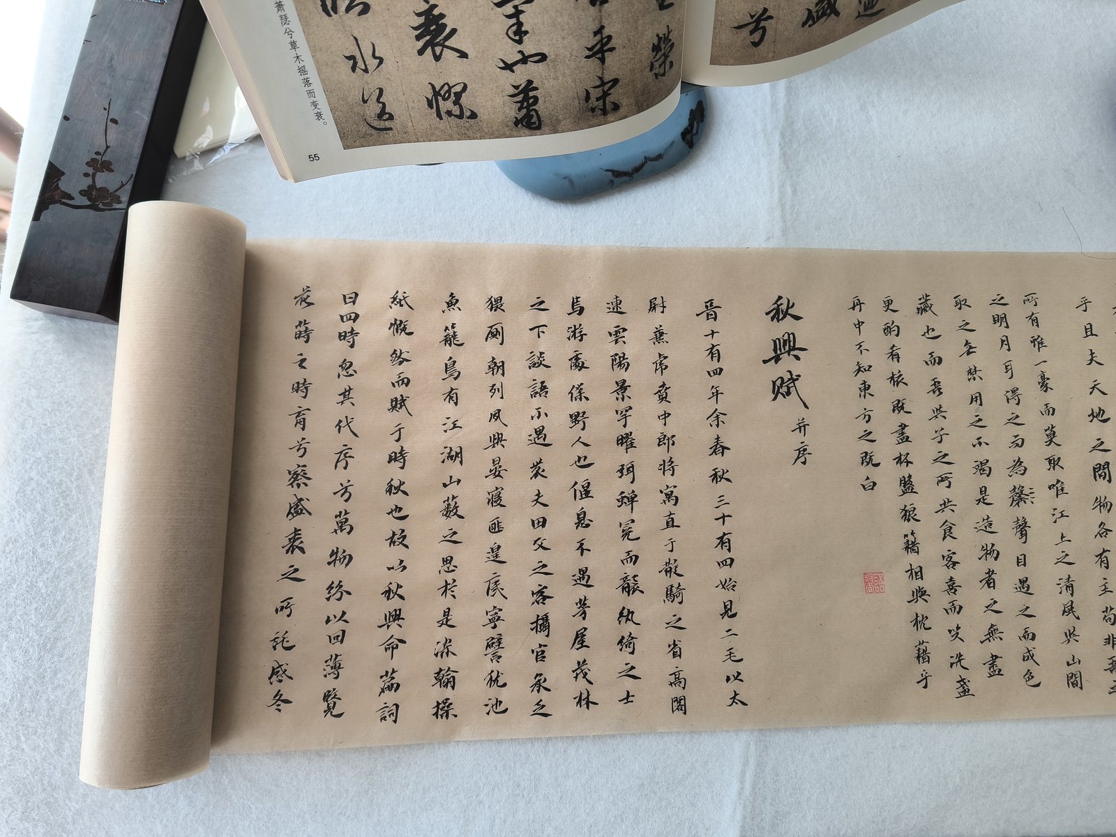 写完的《赤壁赋》长卷,与摊开的《秋兴赋》字帖